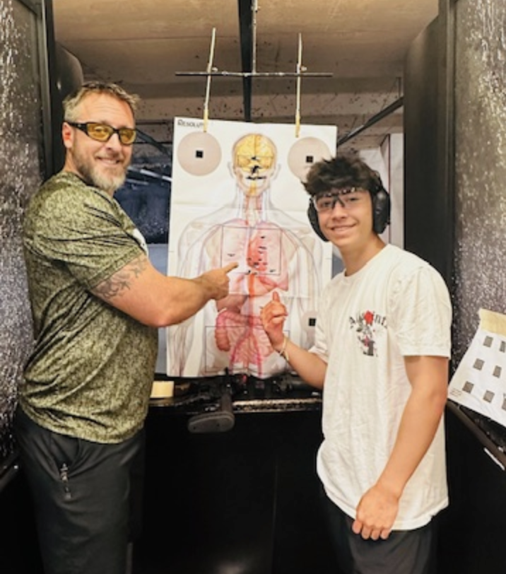 Mike with student at gun range showing off a target