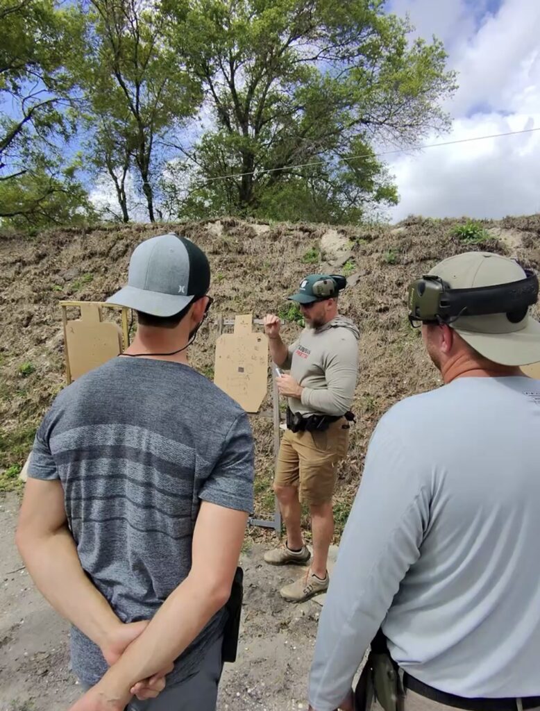 Mike teaching a group of students a firearm shooting lesson